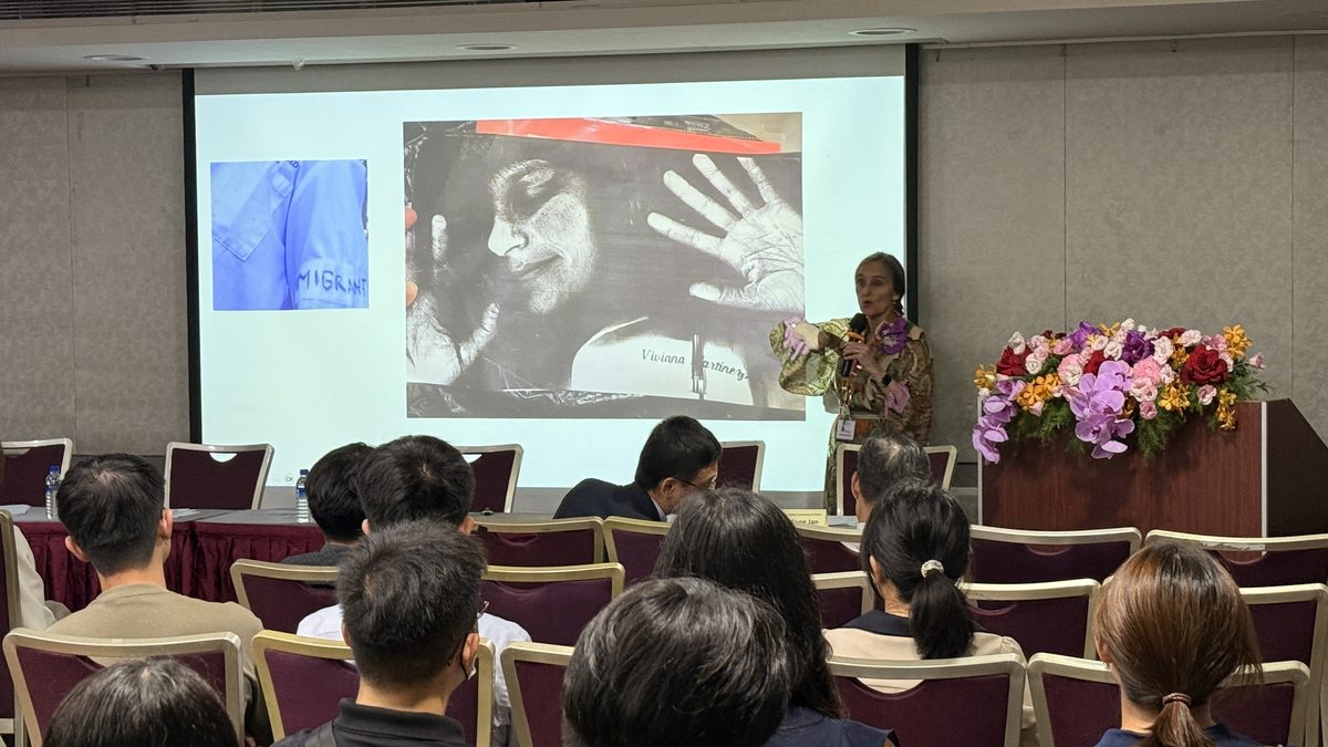 Prof. Viviana Martínez-Bianchi speaking beside a projected slide to an audience of young family physicians